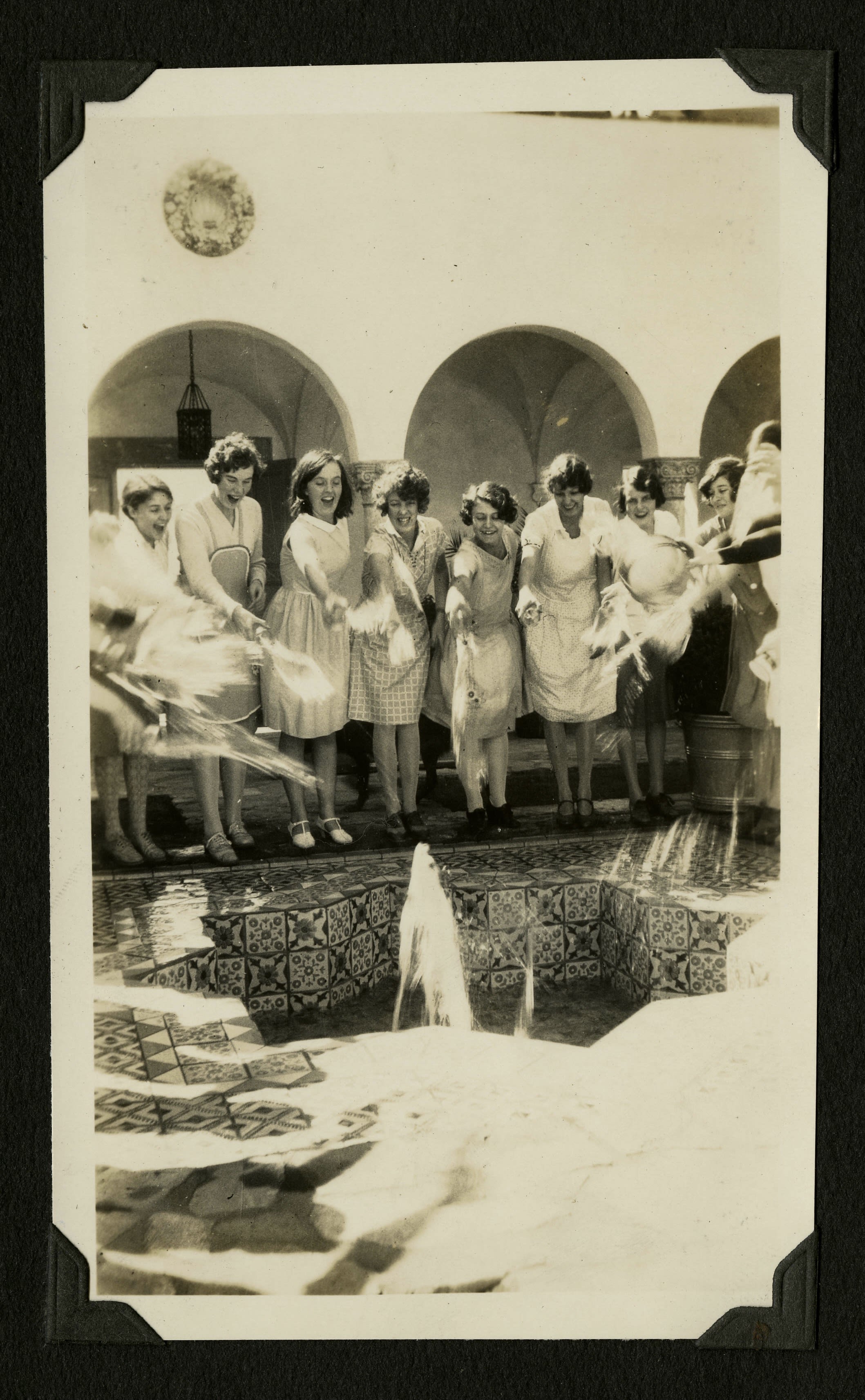 Students throwing water into the fountain at Toll Hall.